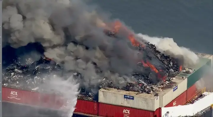 Rescue services are extinguishing a large-scale fire on a barge carrying scrap metal in Delaware Bay