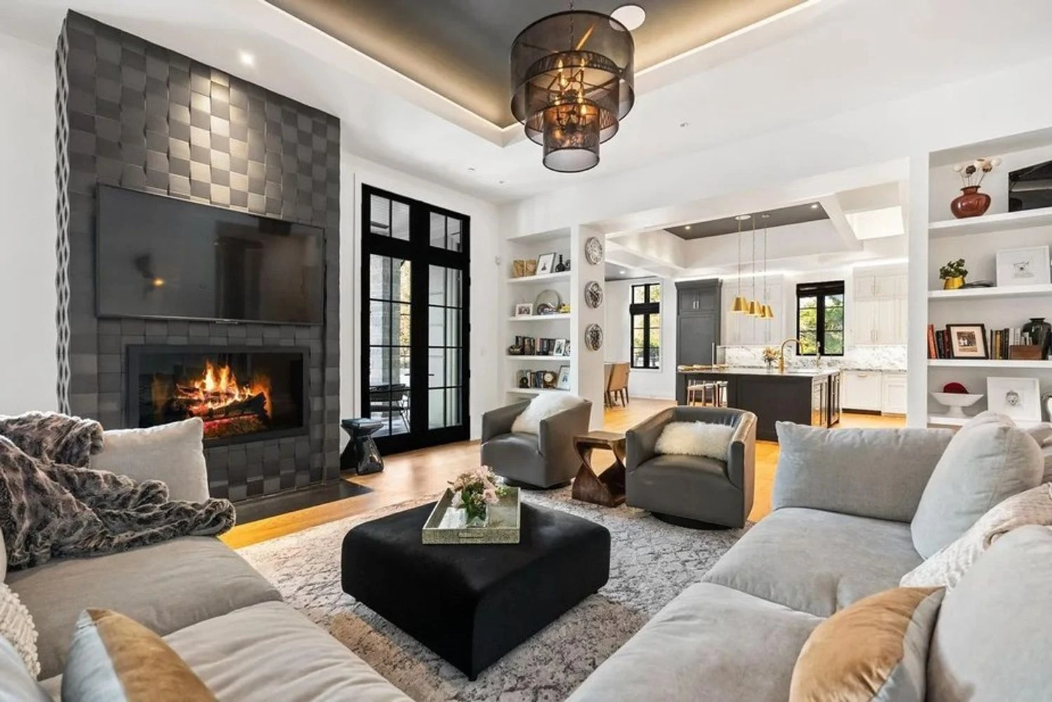 Spacious living room with built-in cabinets and a fireplace opens onto a covered terrace. Realtor.com