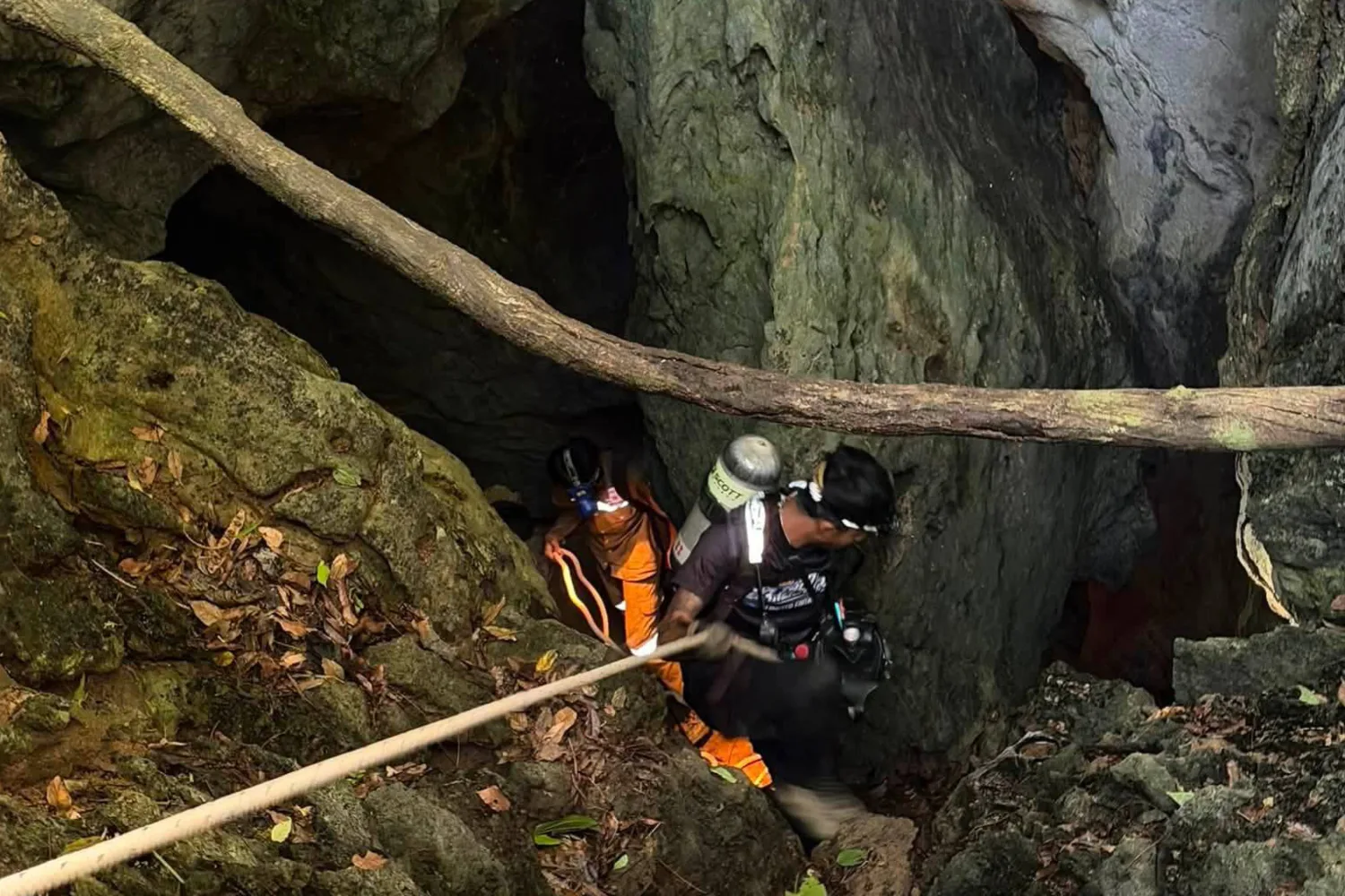 In Laos, heavy rains hamper the search for two people who remain trapped in a flooded cave